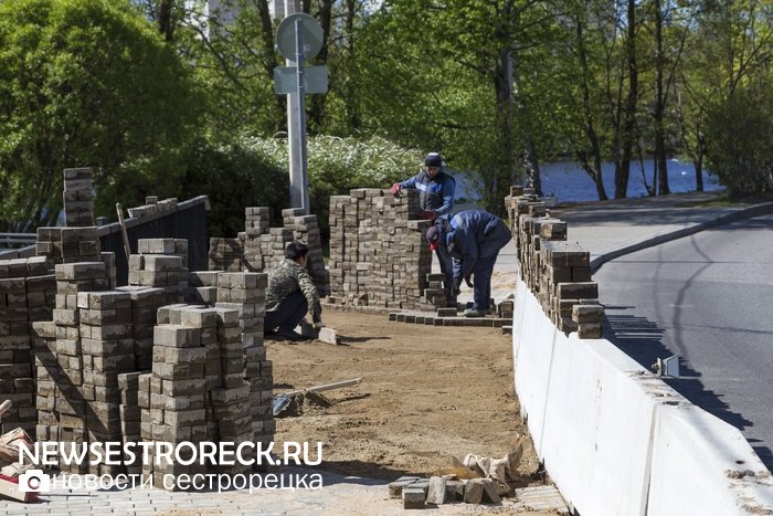 Рабочие перекладывают "пляшущую" плитку на мосту через р. Малая Сестра